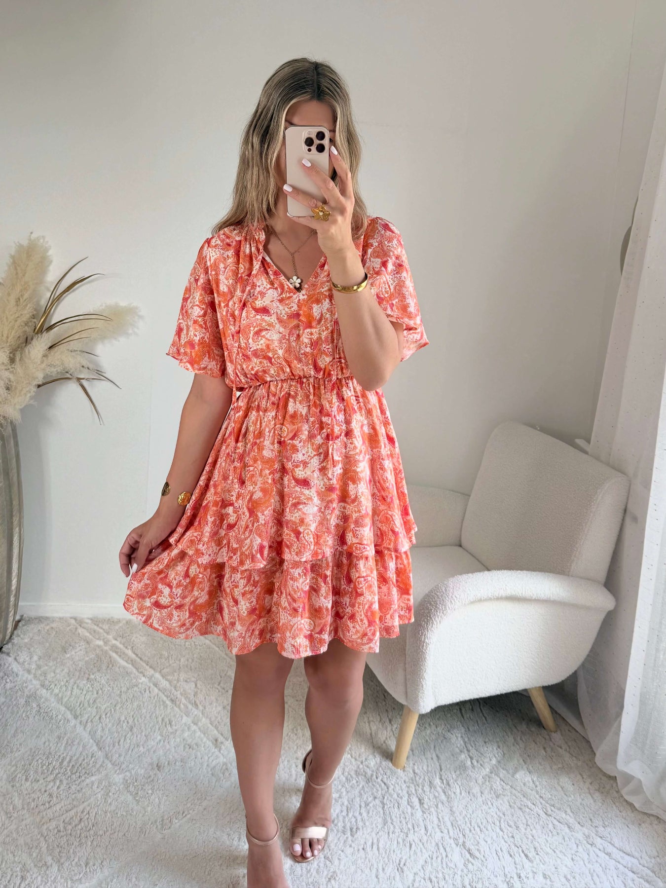 Robe corail à volants Solea, robe courte fluide à imprimé cachemire corail et rose, manches courtes évasées, taille élastiquée et jupe à volants. Modèle féminin et léger idéal pour les journées d’été.