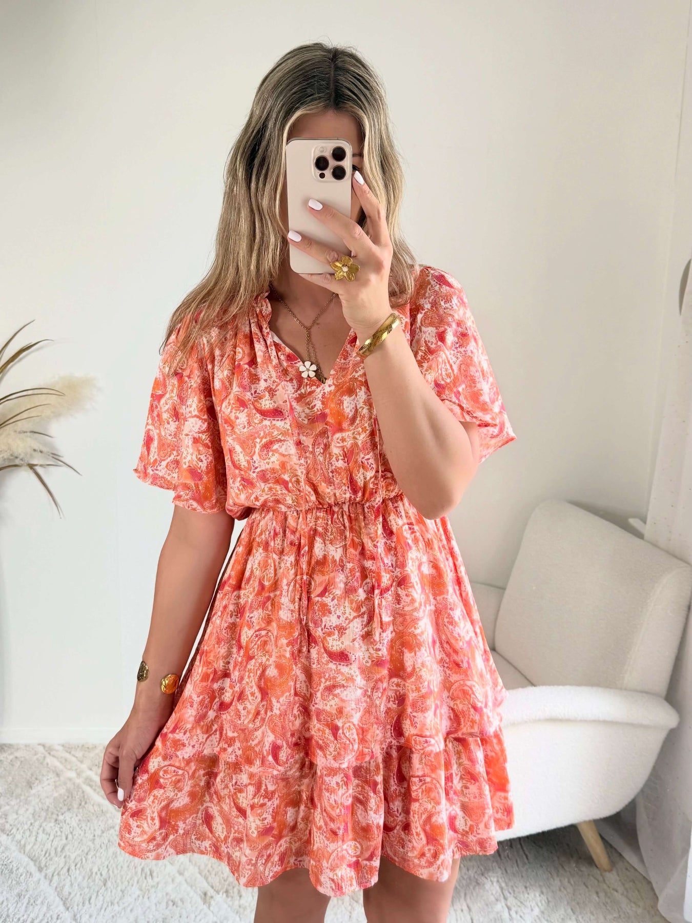 Robe corail à volants Solea, robe courte fluide à imprimé cachemire corail et rose, manches courtes évasées, taille élastiquée et jupe à volants. Modèle féminin et léger idéal pour les journées d’été.