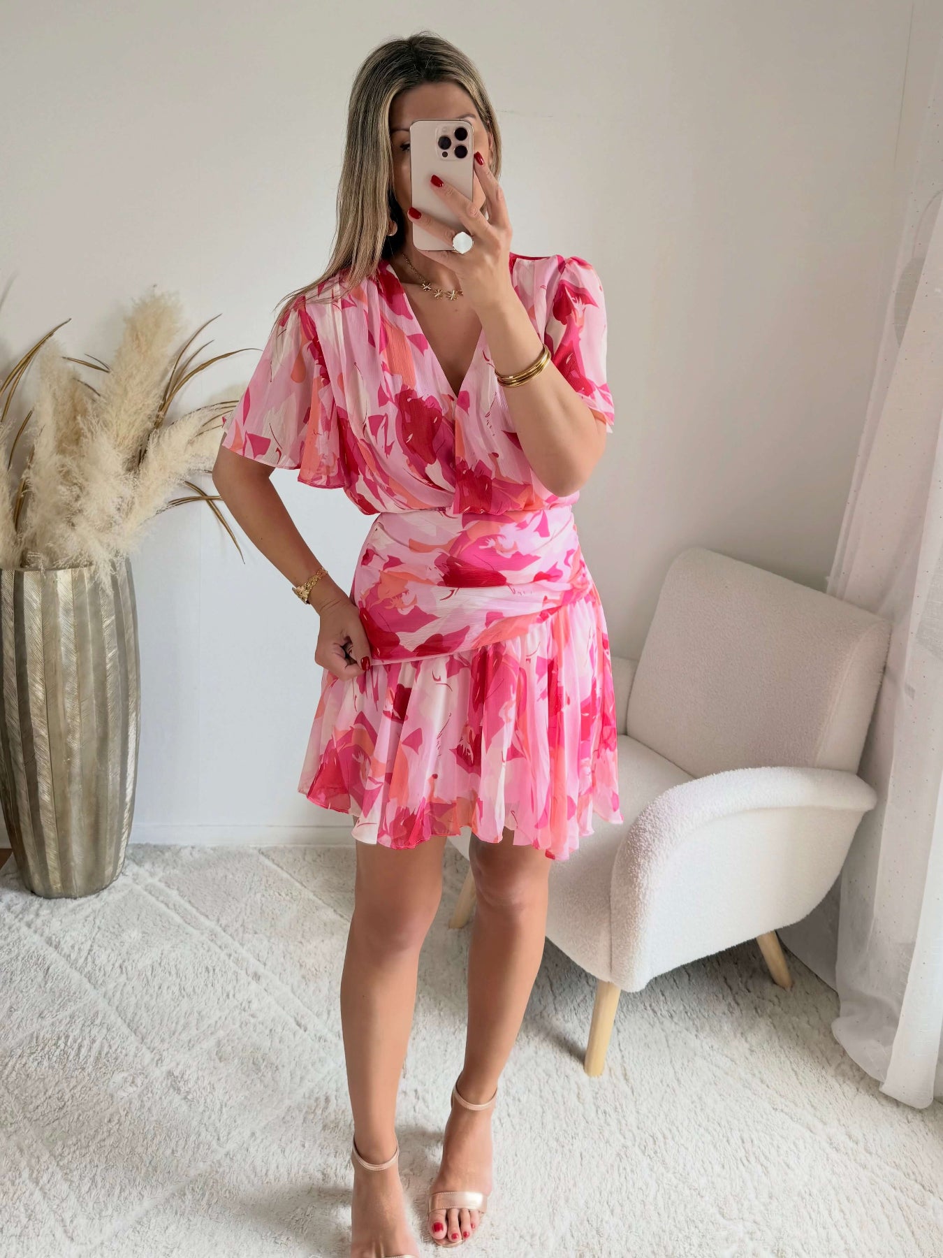 Robe courte rose imprimée Calista avec décolleté cache-cœur, manches fluides et jupe volantée.