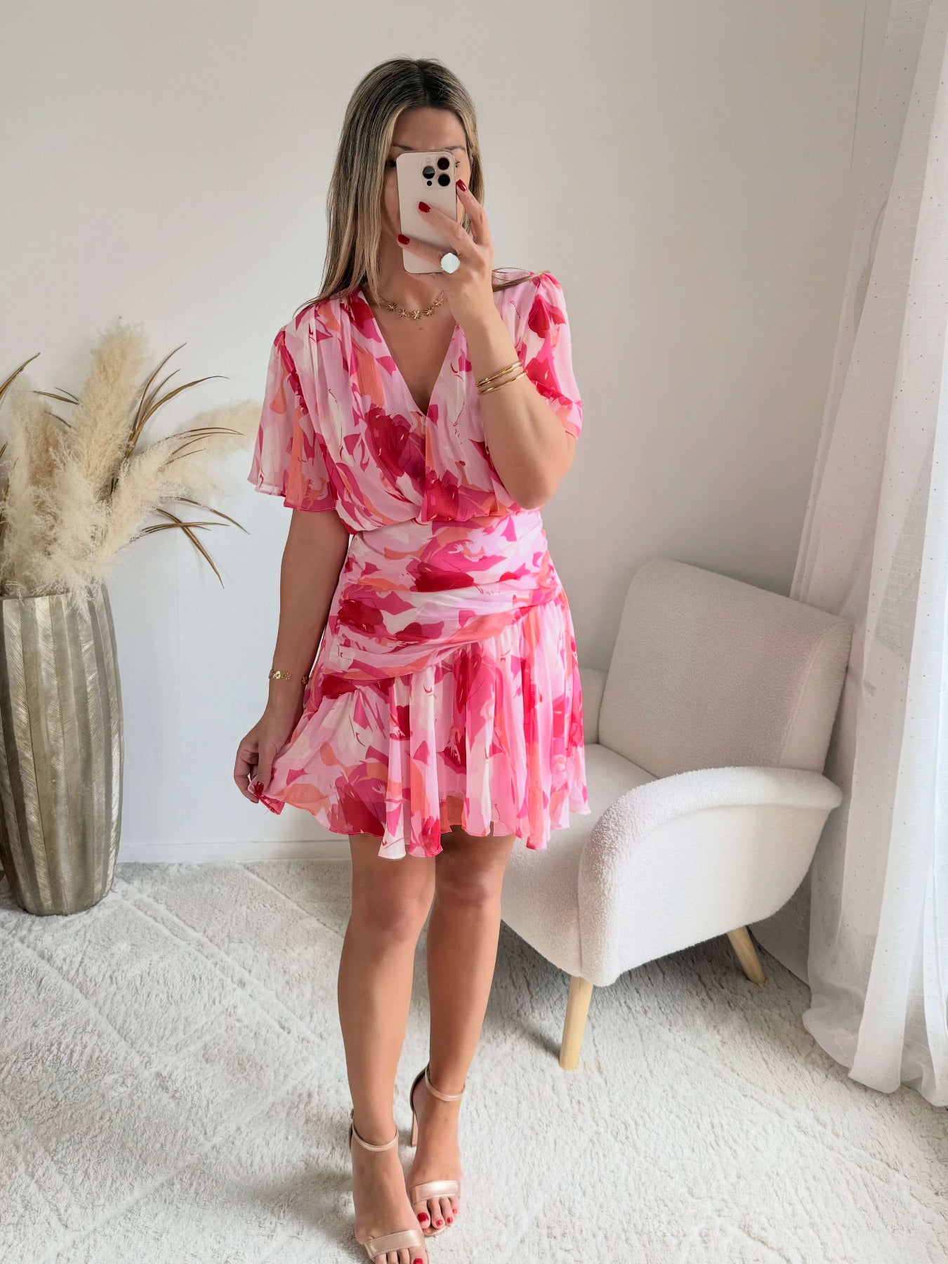 Robe courte rose imprimée Calista avec décolleté cache-cœur, manches fluides et jupe volantée.