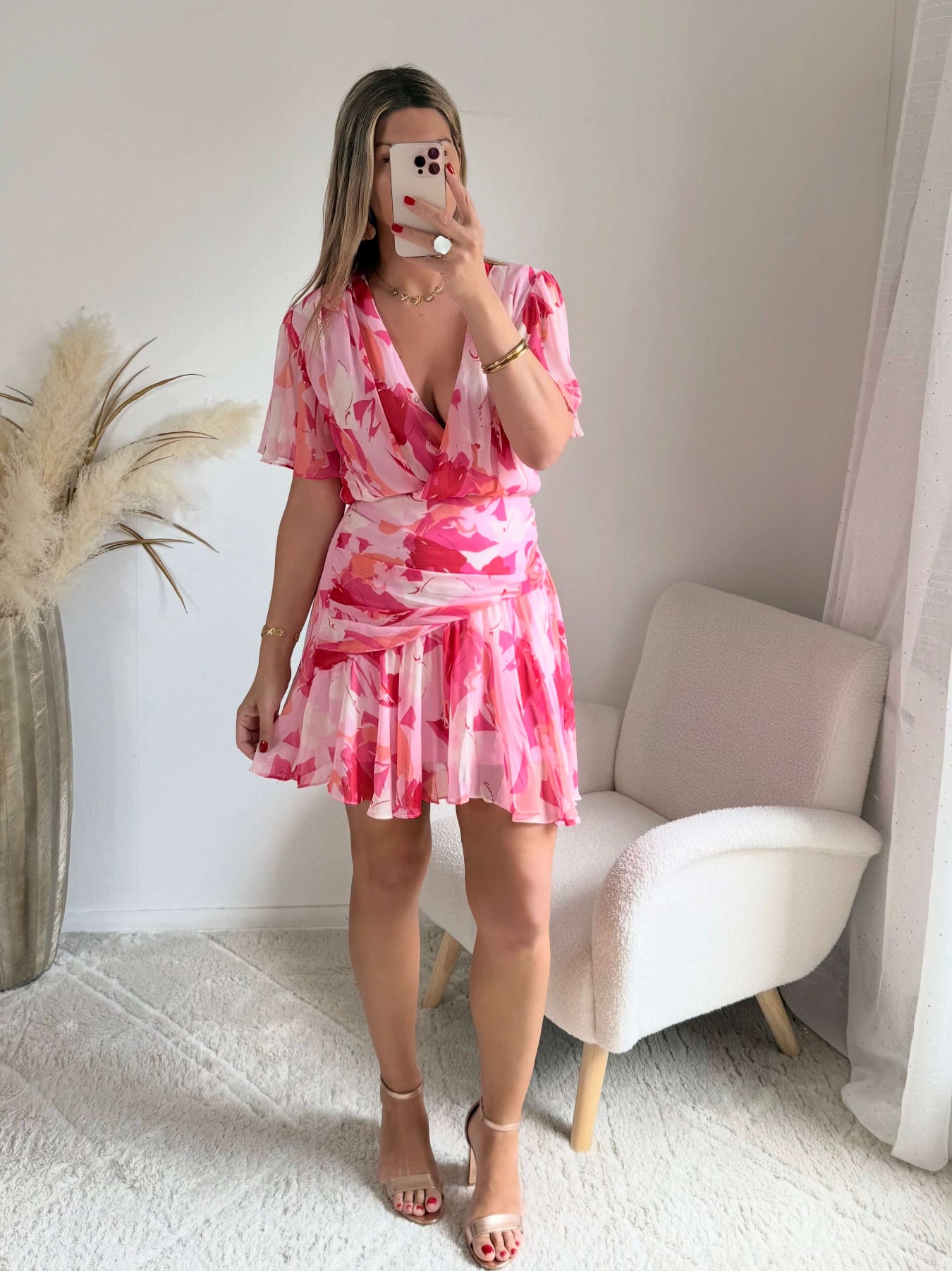 Robe courte rose imprimée Calista avec décolleté cache-cœur, manches fluides et jupe volantée.
