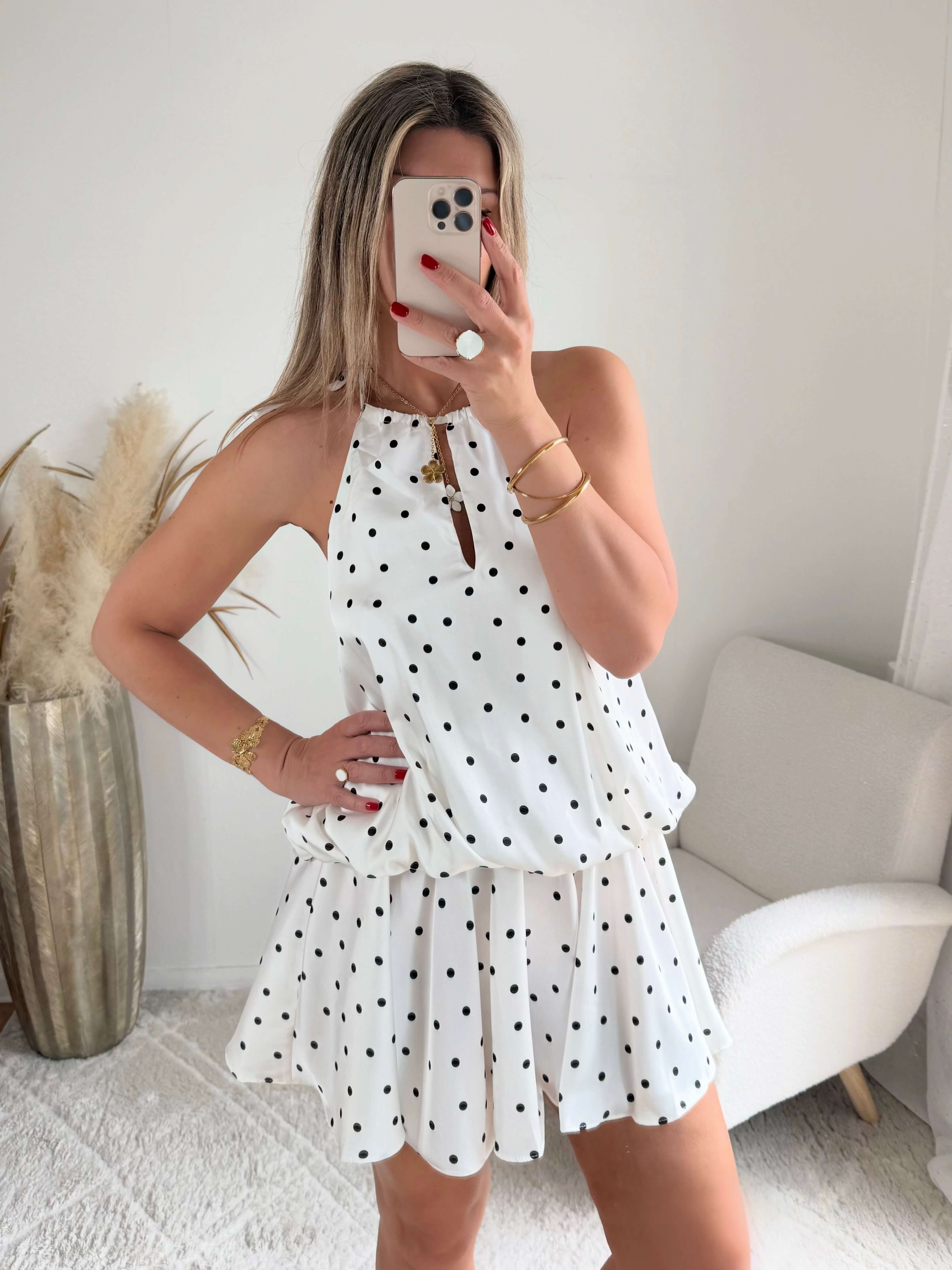 Robe courte Telma blanche à pois noirs avec dos nu et coupe fluide estivale.