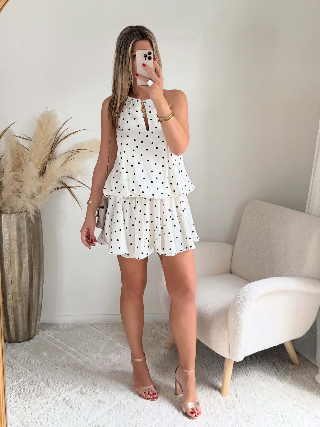 Robe courte Telma blanche à pois noirs avec dos nu et coupe fluide estivale.