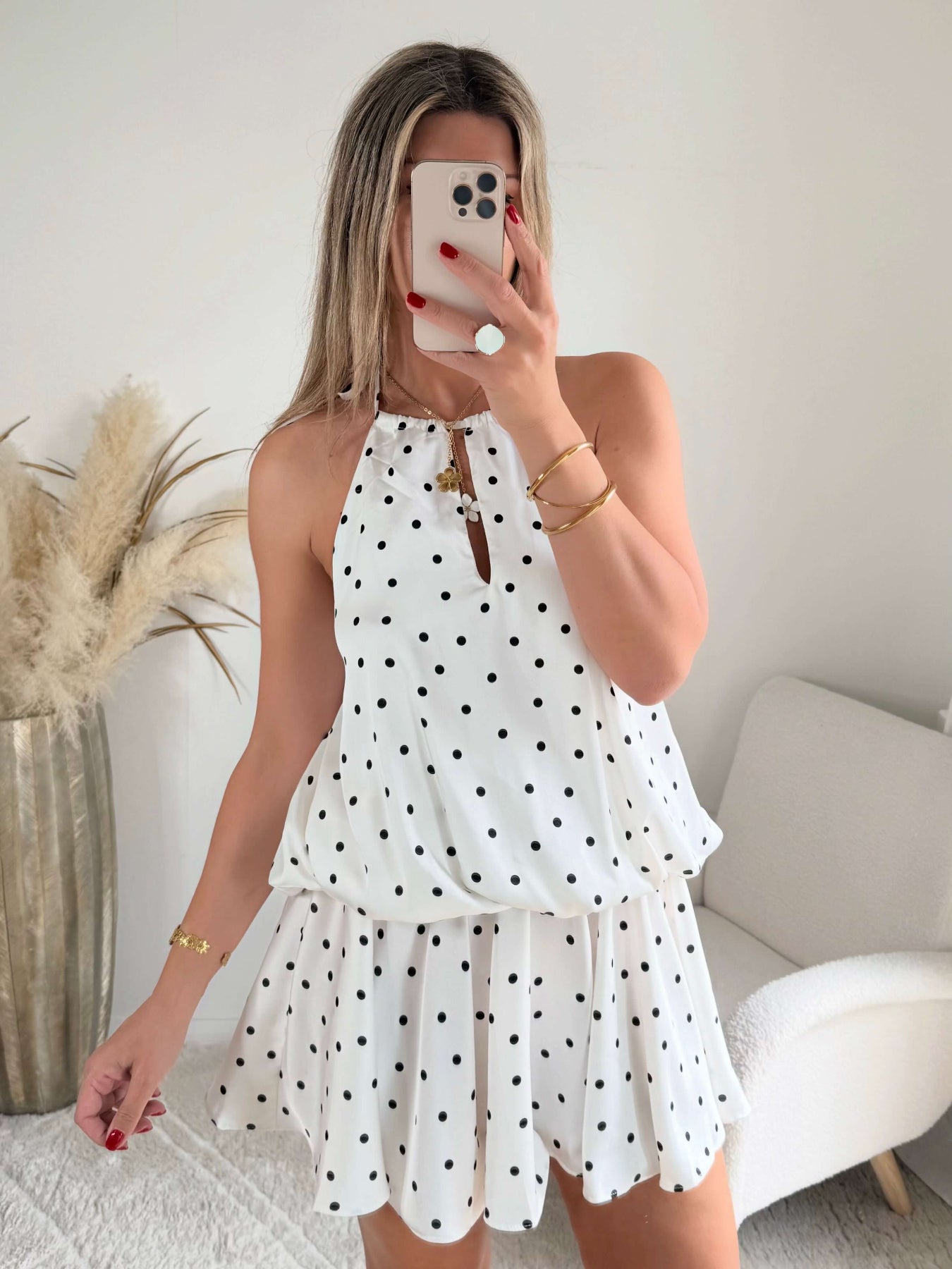 Robe courte Telma blanche à pois noirs avec dos nu et coupe fluide estivale.