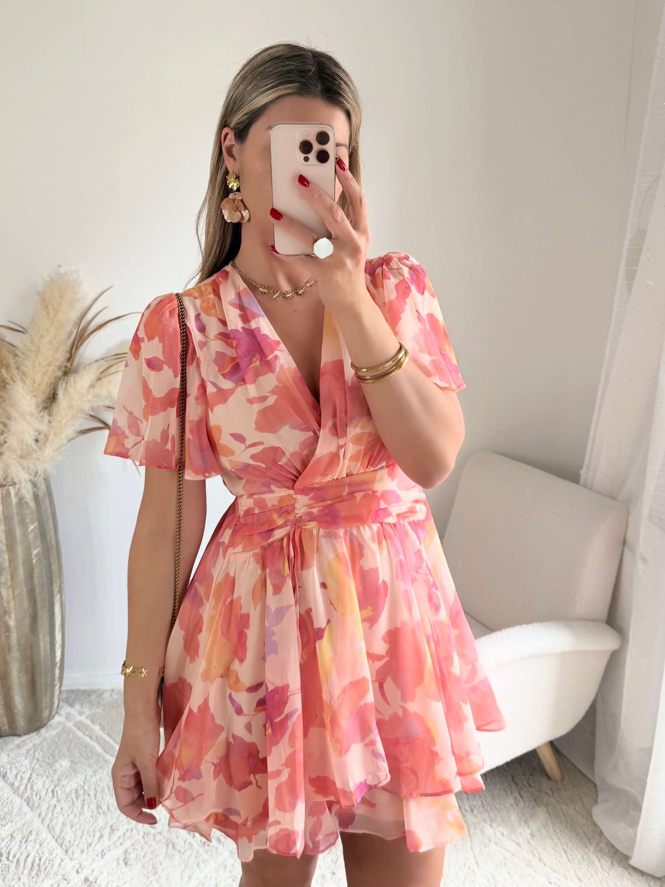 Robe courte rose et pêche imprimée Maëlia avec manches fluides, décolleté cache-cœur et jupe volantée portée par une femme.