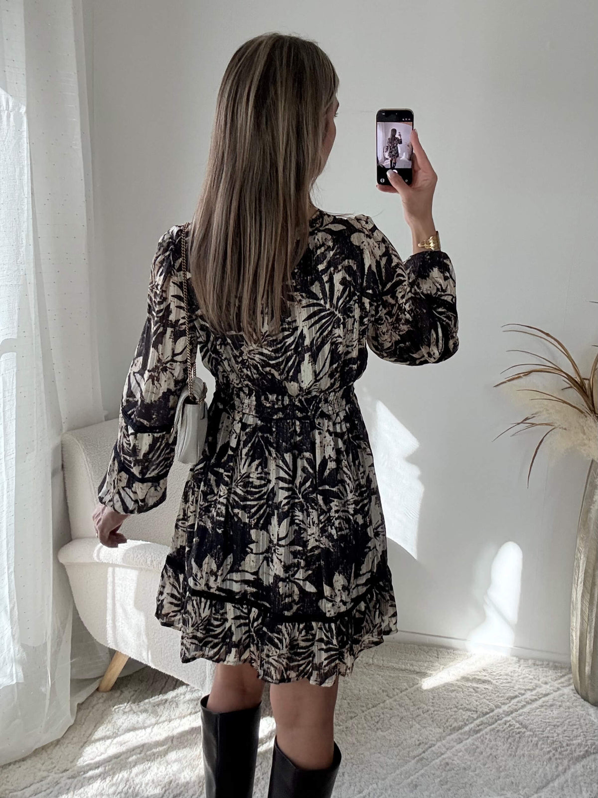 Robe courte noire Bella à imprimé floral écru, manches longues et taille élastiquée.