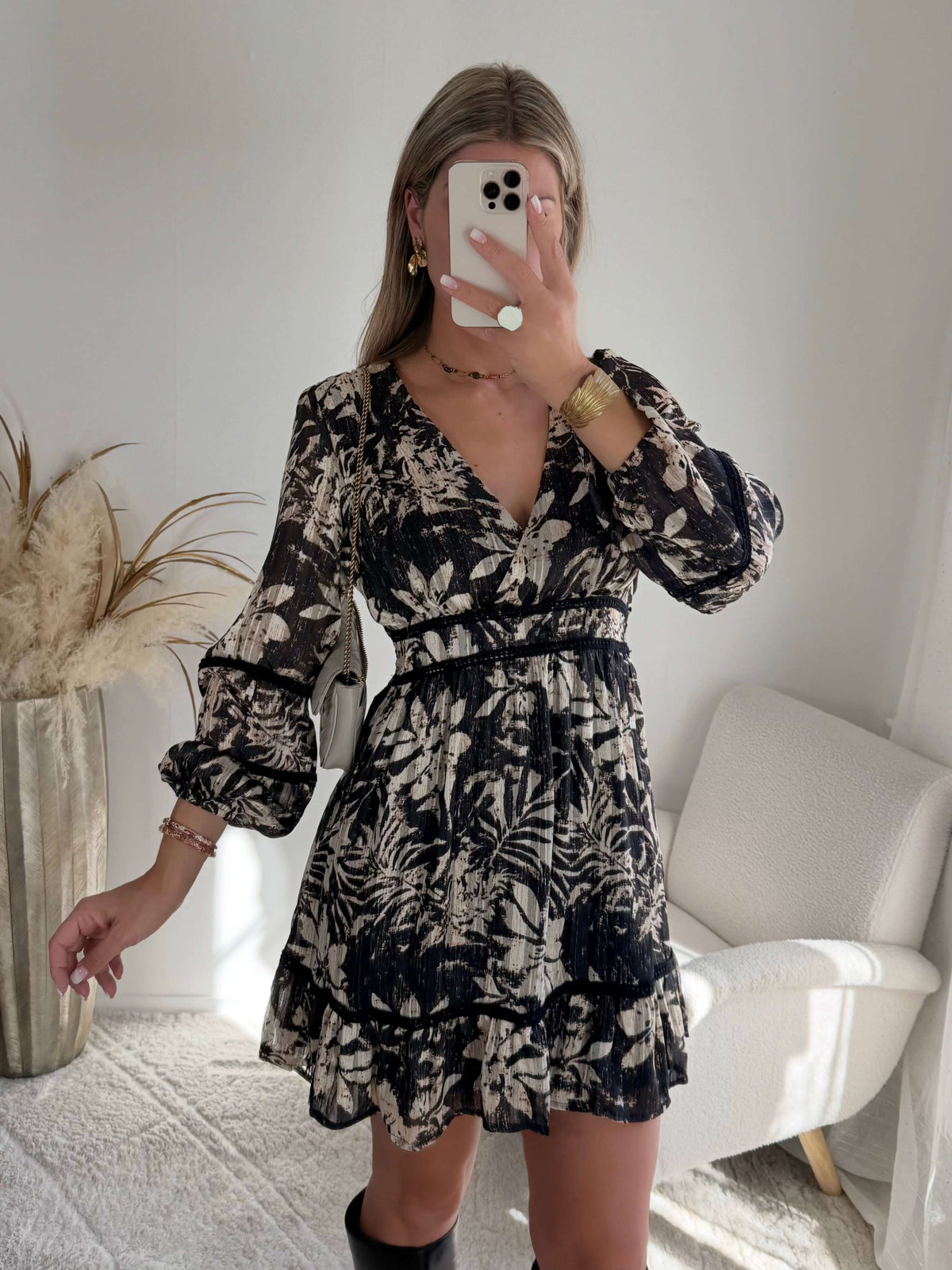 Robe courte noire Bella à imprimé floral écru, manches longues et taille élastiquée.