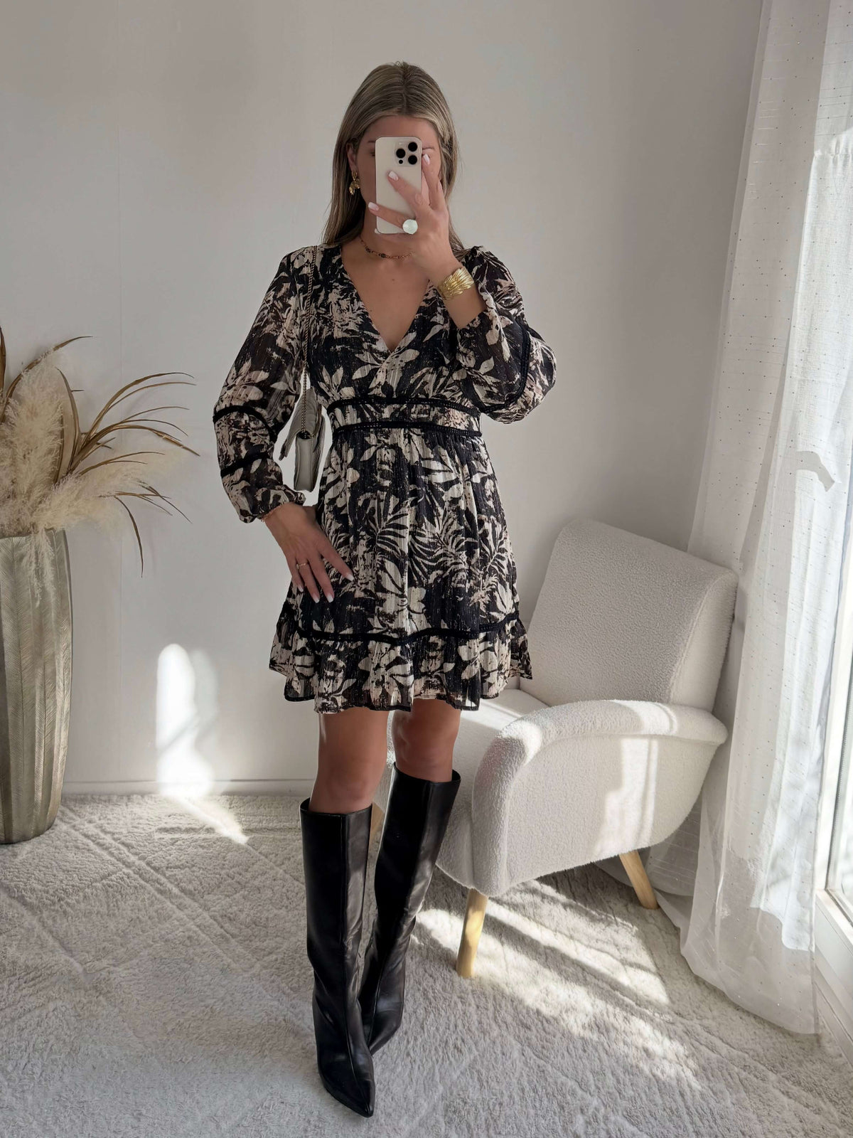 Robe courte noire Bella à imprimé floral écru, manches longues et taille élastiquée.
