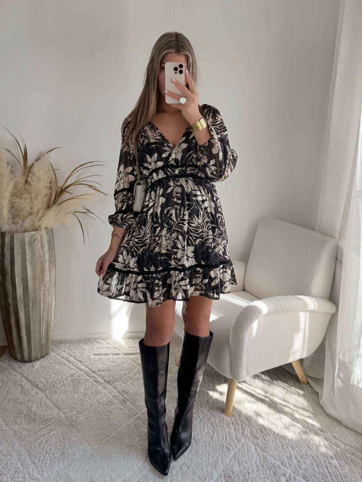 Robe courte noire Bella à imprimé floral écru, manches longues et taille élastiquée.
