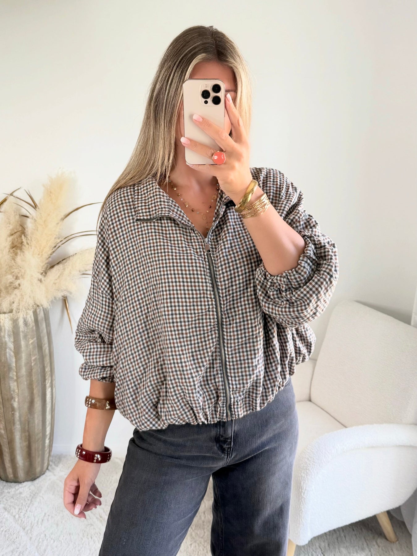 Femme portant le blouson court Tao à petits carreaux gris, marron et écru.