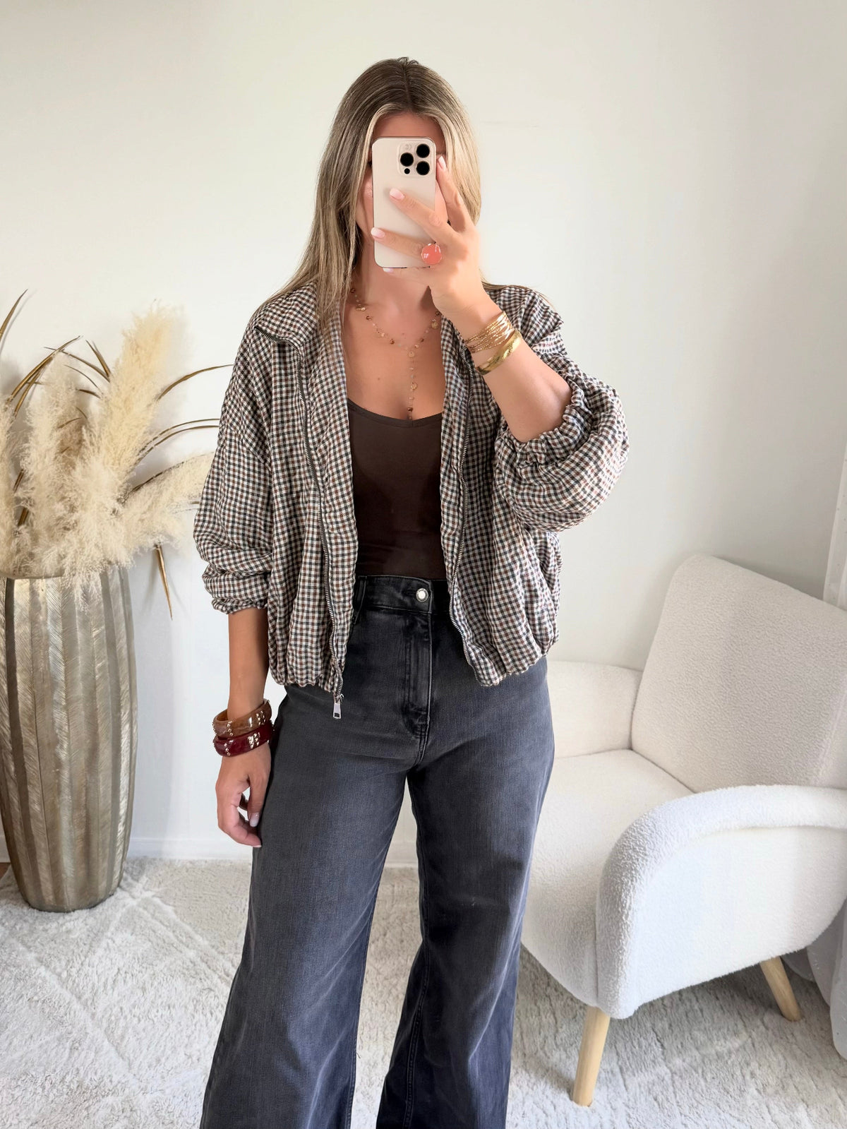 Femme portant le blouson court Tao à petits carreaux gris, marron et écru.