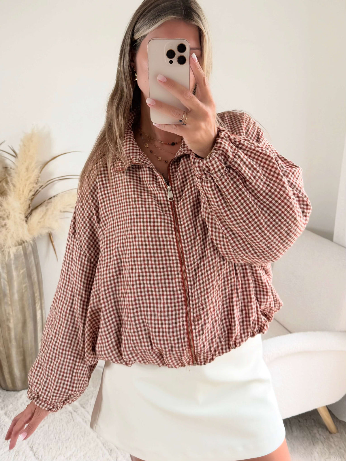 Femme portant le blouson court Tao à petits carreaux rouille et écru.