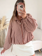 Femme portant le blouson court Tao à petits carreaux rouille et écru.