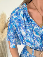 Robe bleue à volants Solea, robe courte fluide à imprimé cachemire bleue manches courtes évasées, taille élastiquée et jupe à volants. Modèle féminin et léger idéal pour les journées d’été.