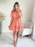 Robe corail à volants Solea, robe courte fluide à imprimé cachemire corail et rose, manches courtes évasées, taille élastiquée et jupe à volants. Modèle féminin et léger idéal pour les journées d’été.