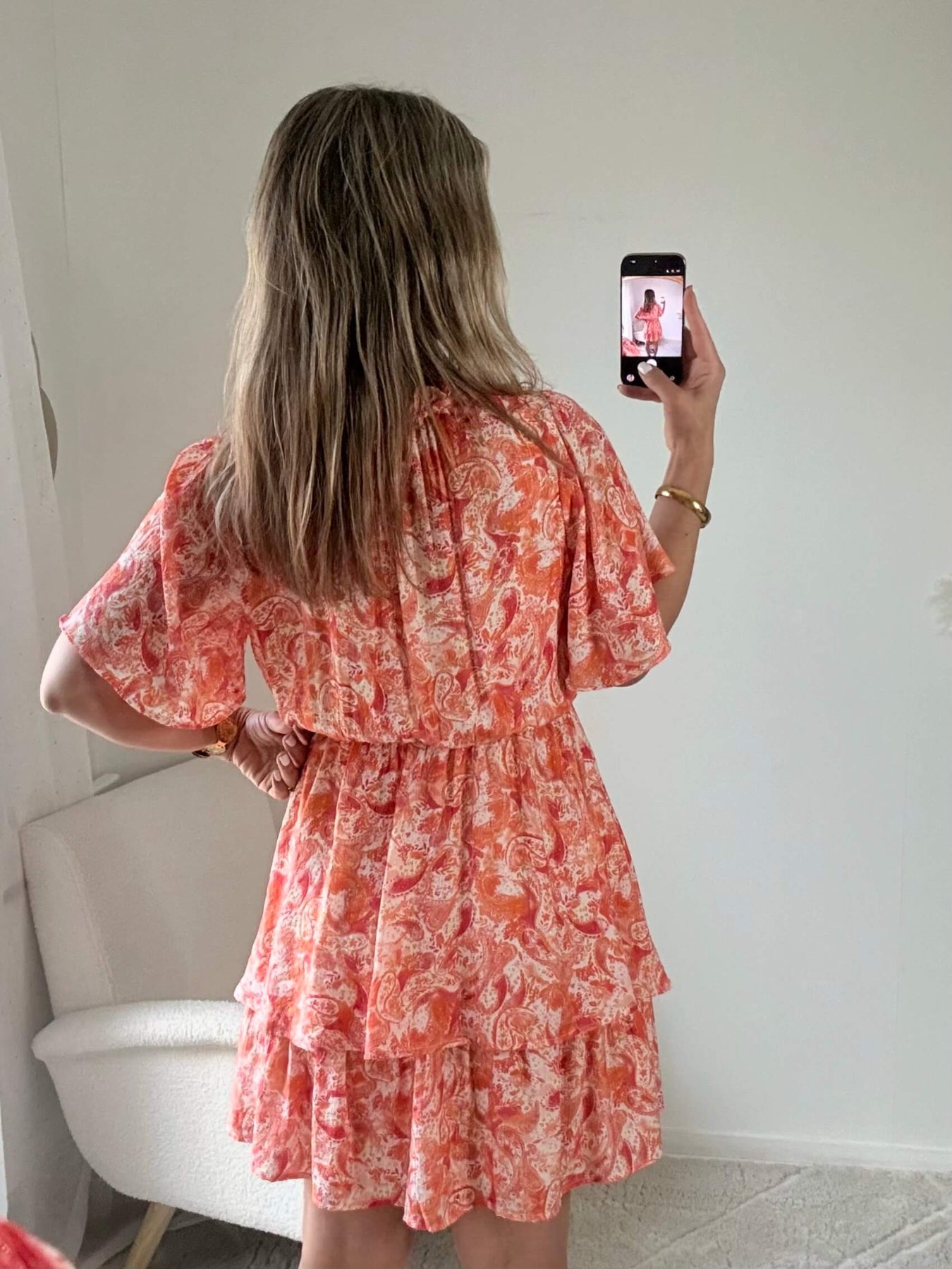 Robe corail à volants Solea, robe courte fluide à imprimé cachemire corail et rose, manches courtes évasées, taille élastiquée et jupe à volants. Modèle féminin et léger idéal pour les journées d’été.