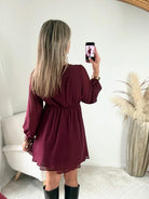 Robe courte bordeaux Cali disponible du S/M au 4XL, avec décolleté en V, manches longues et taille élastiquée.