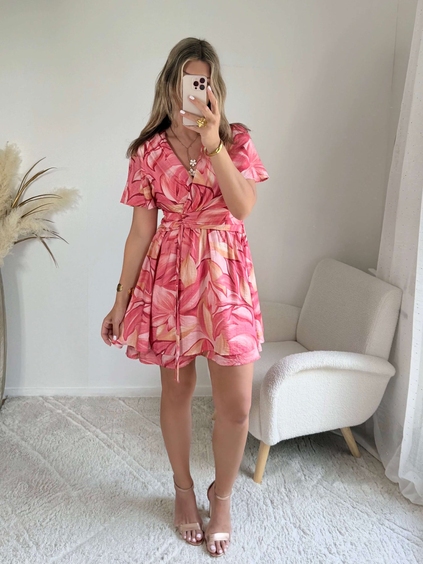 Robe Hany rose corail à imprimé floral, coupe courte fluide avec manches volantées, décolleté croisé et ceinture à nouer à la taille. Disponible du S au 4XL.