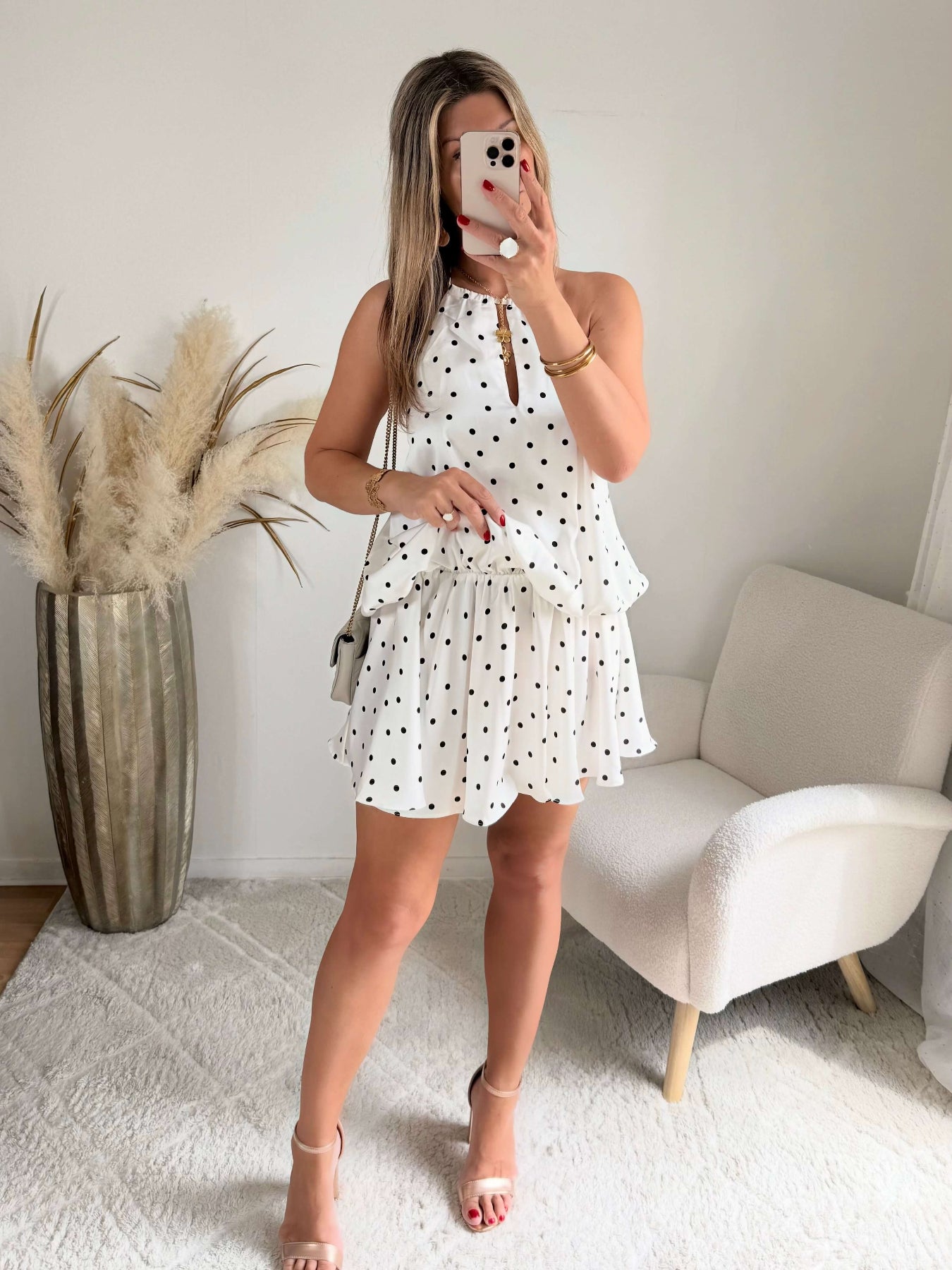 Robe courte Telma blanche à pois noirs avec dos nu et coupe fluide estivale.