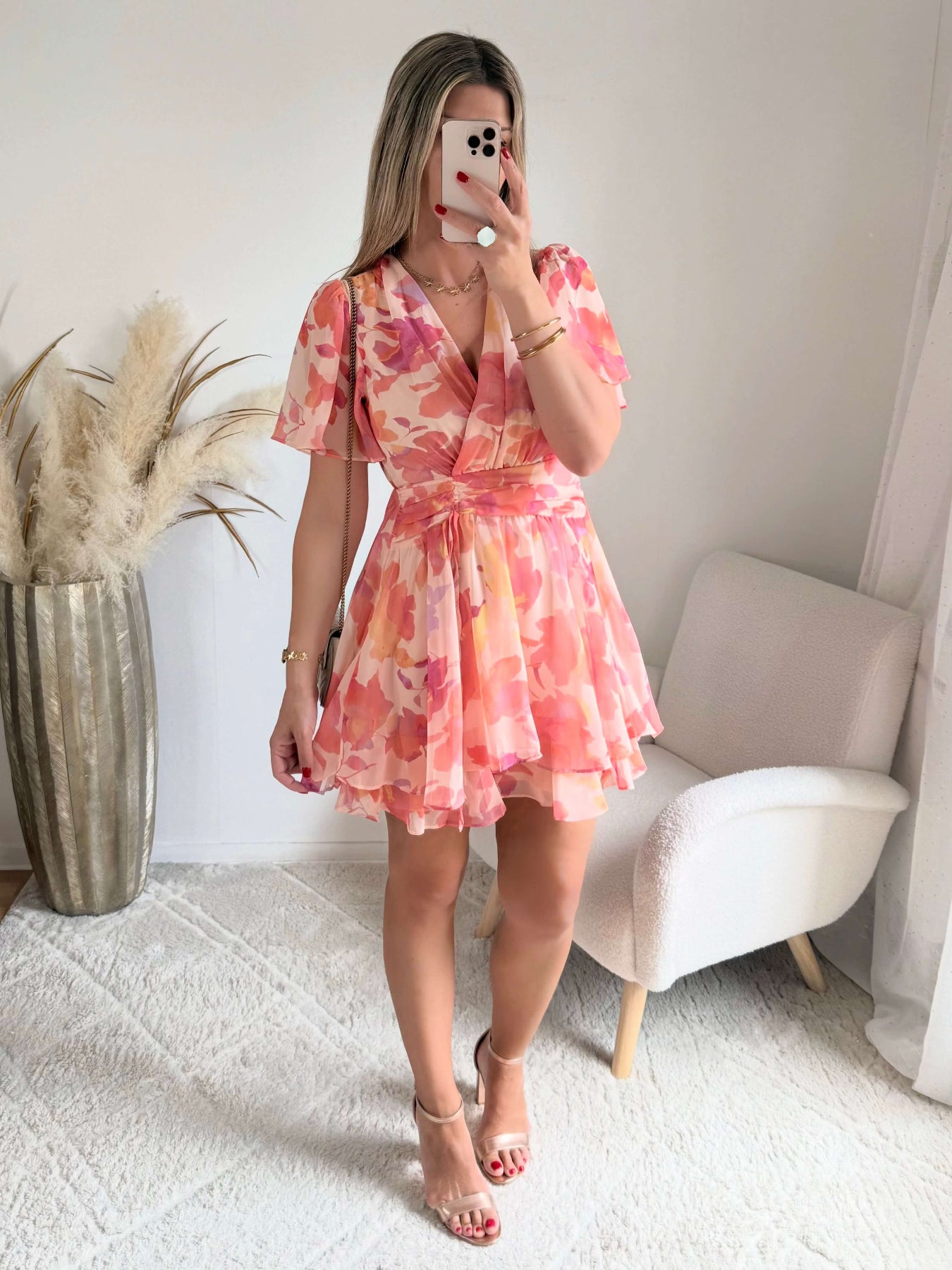 Robe courte rose et pêche imprimée Maëlia avec manches fluides, décolleté cache-cœur et jupe volantée portée par une femme.