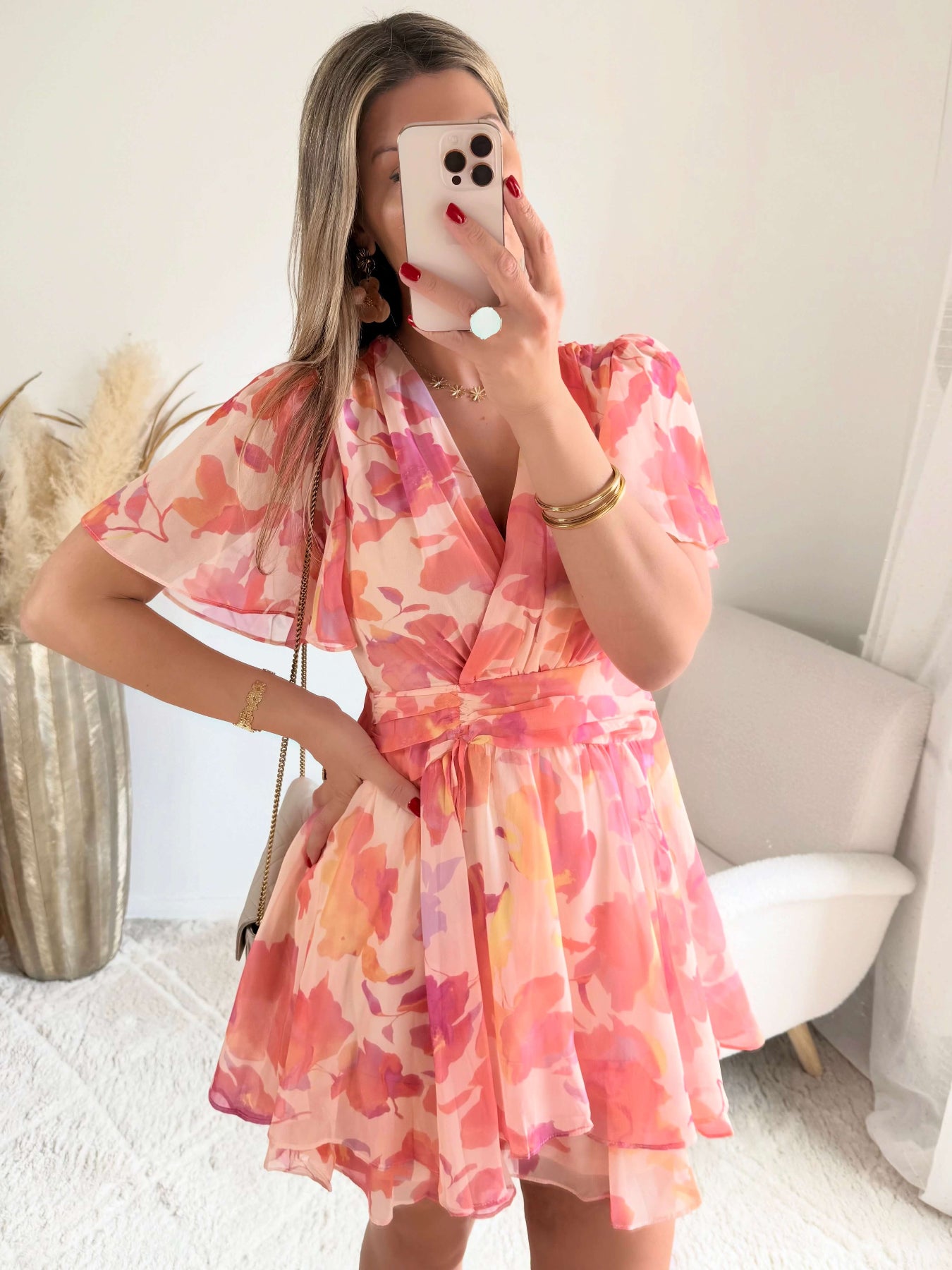 Robe courte rose et pêche imprimée Maëlia avec manches fluides, décolleté cache-cœur et jupe volantée portée par une femme.