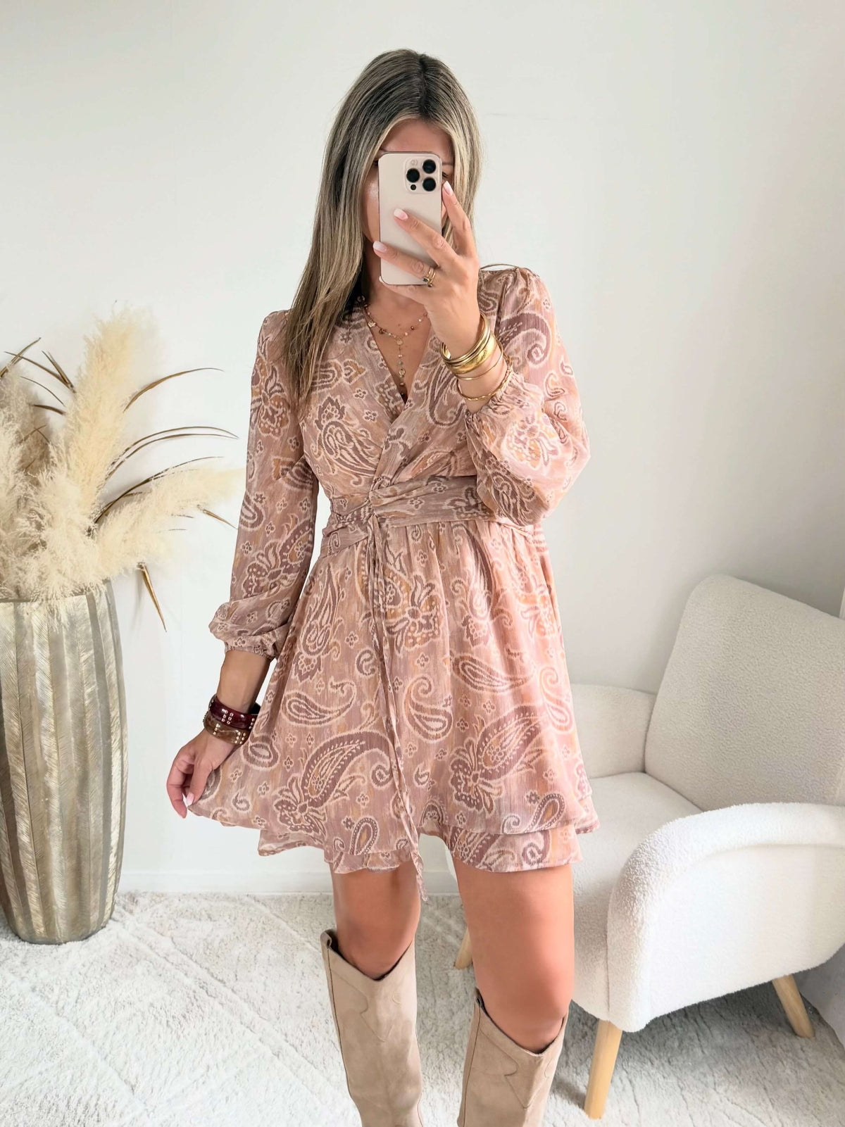 Robe courte Oxane rose poudré à imprimé cachemire, du S au 4XL, avec décolleté cache-cœur et jupe à volants, portée avec des bottes beiges.