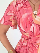 Robe Hany rose corail à imprimé floral, coupe courte fluide avec manches volantées, décolleté croisé et ceinture à nouer à la taille. Disponible du S au 4XL.