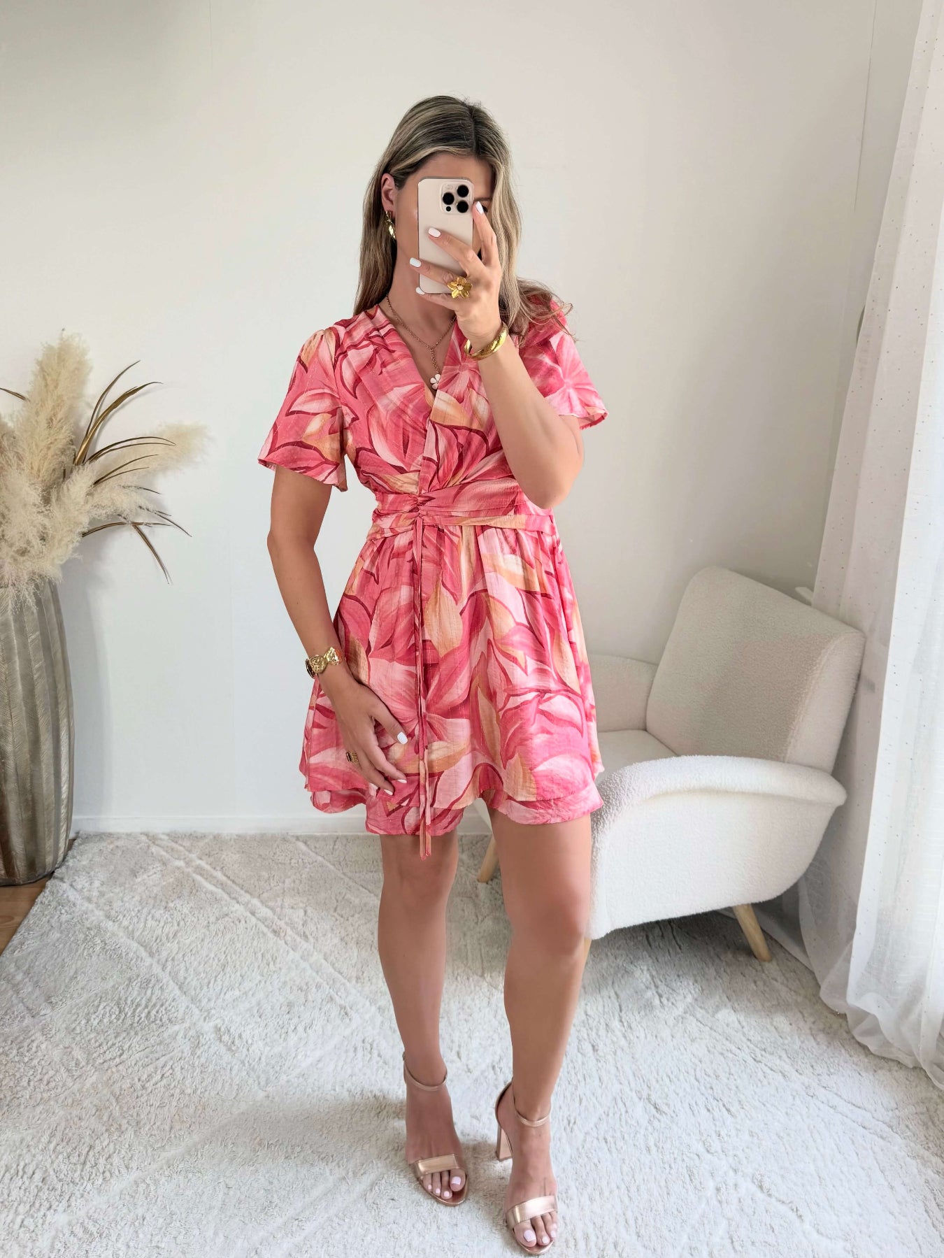 Robe Hany rose corail à imprimé floral, coupe courte fluide avec manches volantées, décolleté croisé et ceinture à nouer à la taille. Disponible du S au 4XL.