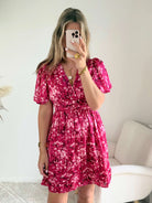 Robe courte fuchsia fleurie Guilia pour femme, coupe portefeuille, manches courtes, idéale pour les cérémonies, mariages et occasions estivales.