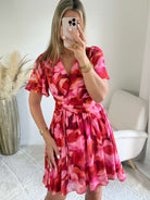 Robe courte Bianca imprimée rose et rouge coupe fluide avec décolleté en V, manches courtes.
