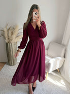 Femme portant la robe longue bordeaux Zoé à manches longues, décolleté cache-cœur et taille froncée.