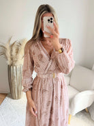Femme portant une robe longue fendue beige et dorée
