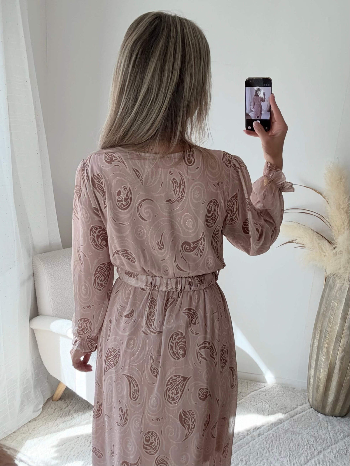 Femme portant une robe longue fendue beige et dorée