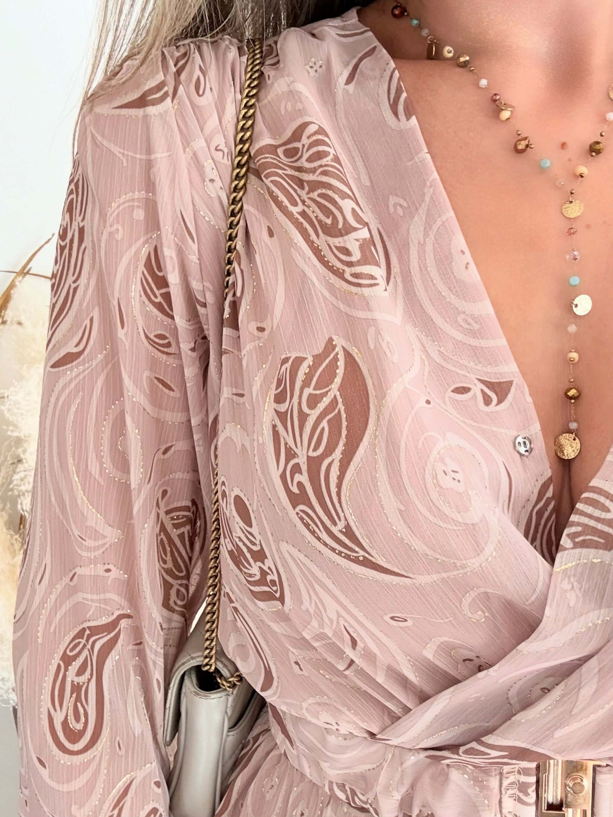 Femme portant une robe longue fendue beige et dorée