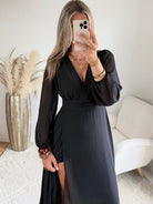 Robe longue fendue Lyana noire, décolleté cache-cœur et manches longues.
