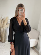 Robe longue fendue Lyana noire, décolleté cache-cœur et manches longues.