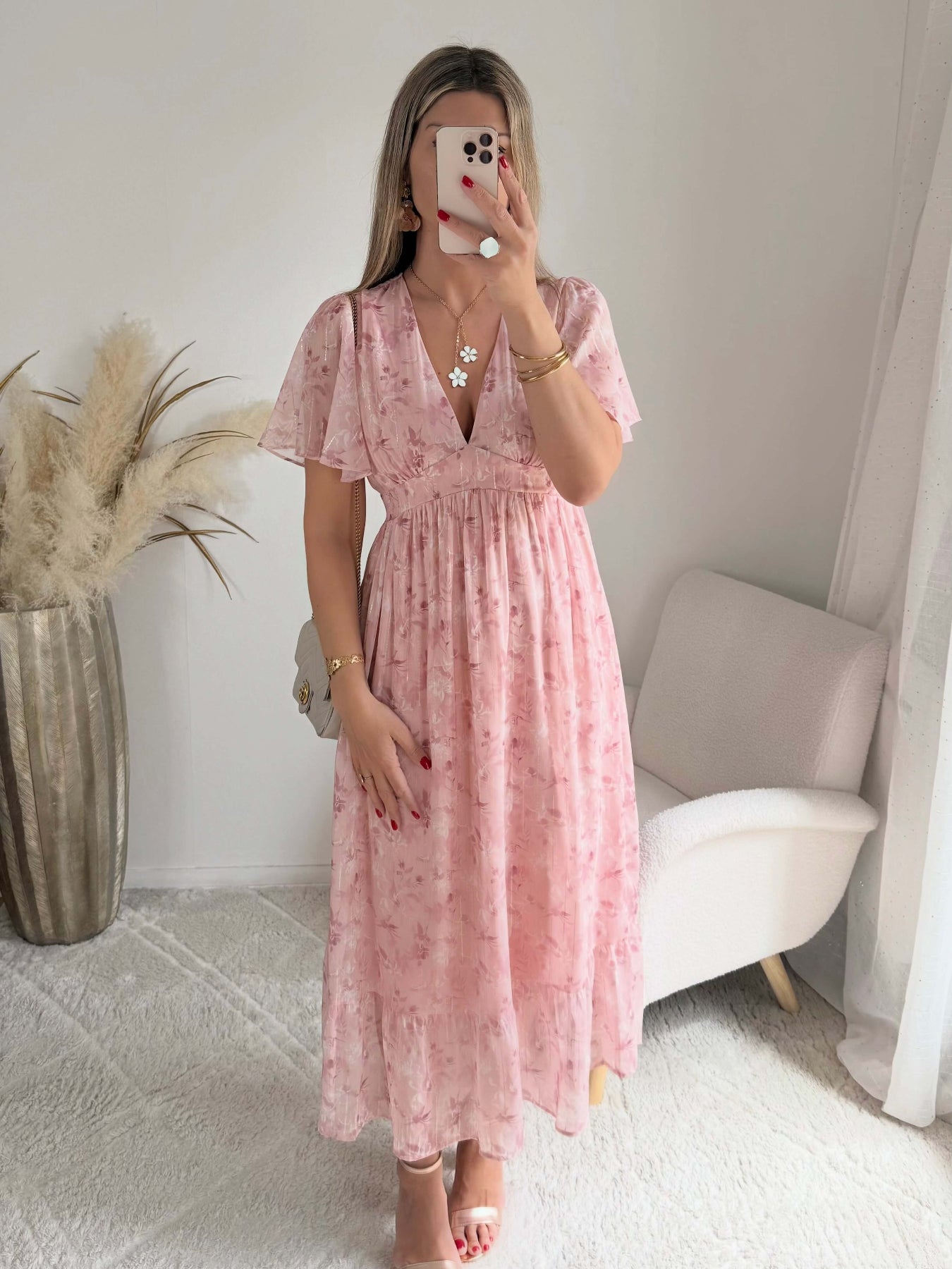 Robe longue rose poudré fleurie Naëlle avec manches fluides et décolleté cache-cœur portée par une femme.