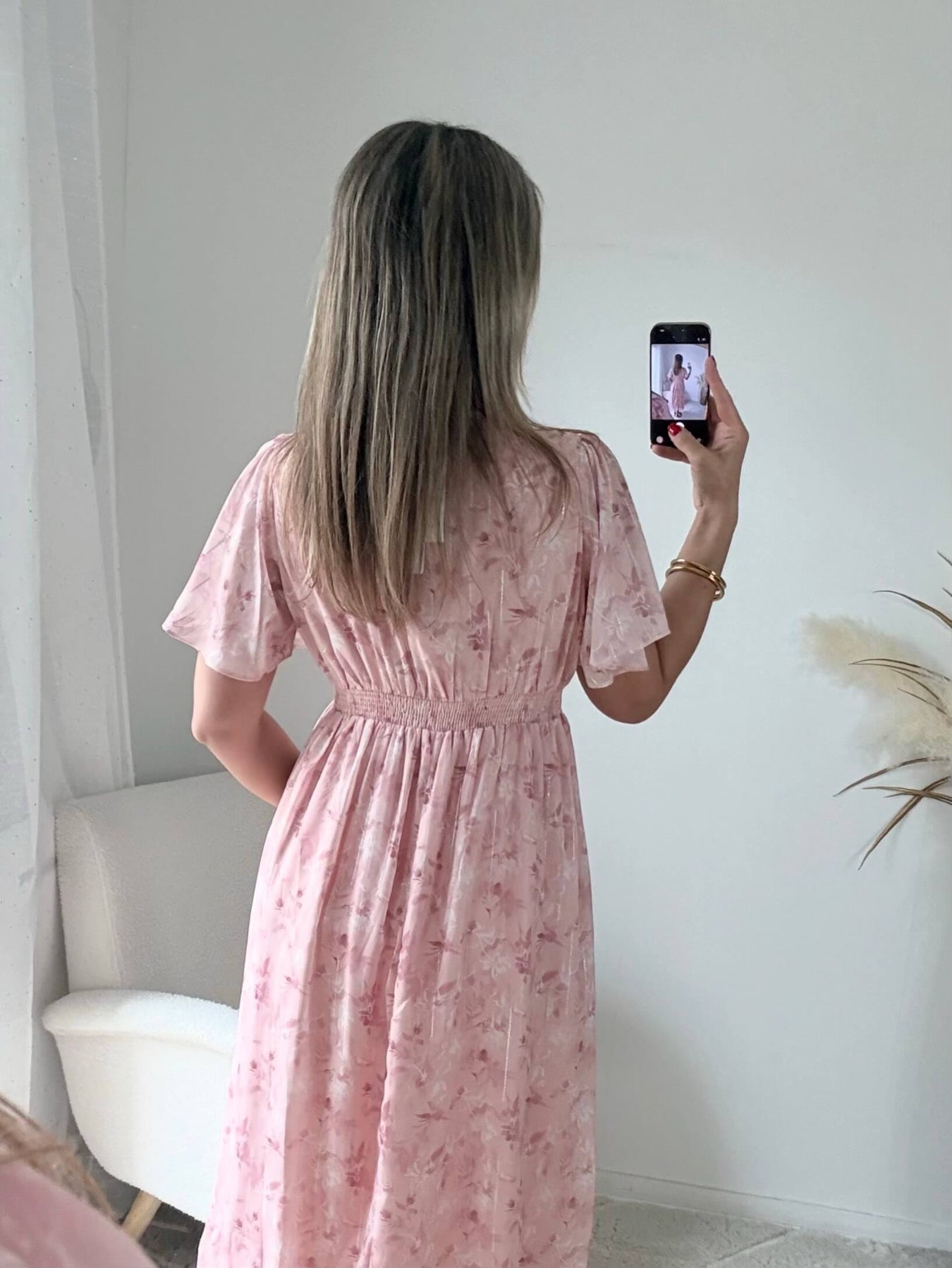 Robe longue rose poudré fleurie Naëlle avec manches fluides et décolleté cache-cœur portée par une femme.