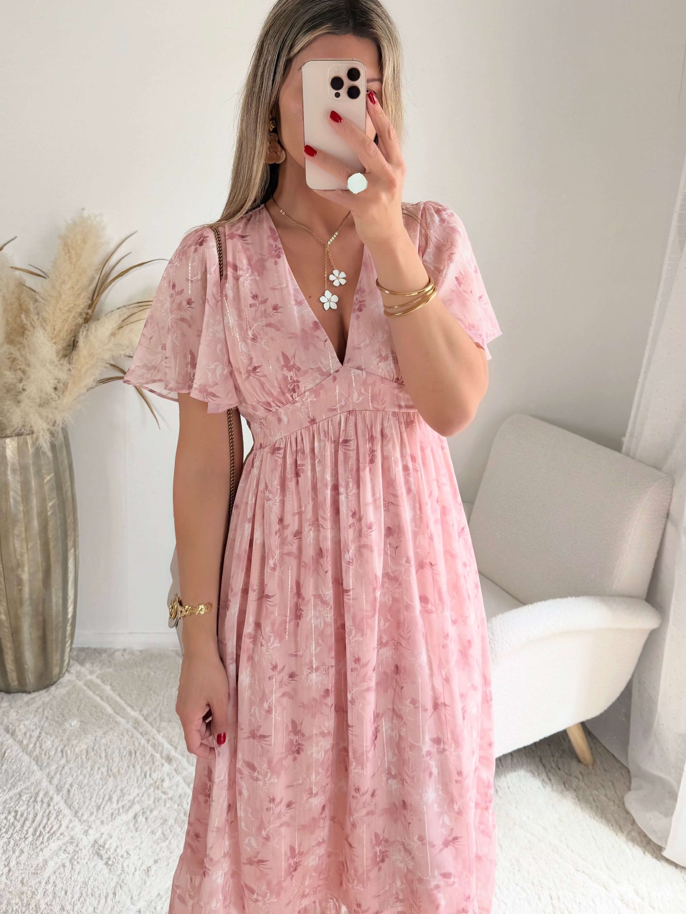 Robe longue rose poudré fleurie Naëlle avec manches fluides et décolleté cache-cœur portée par une femme.
