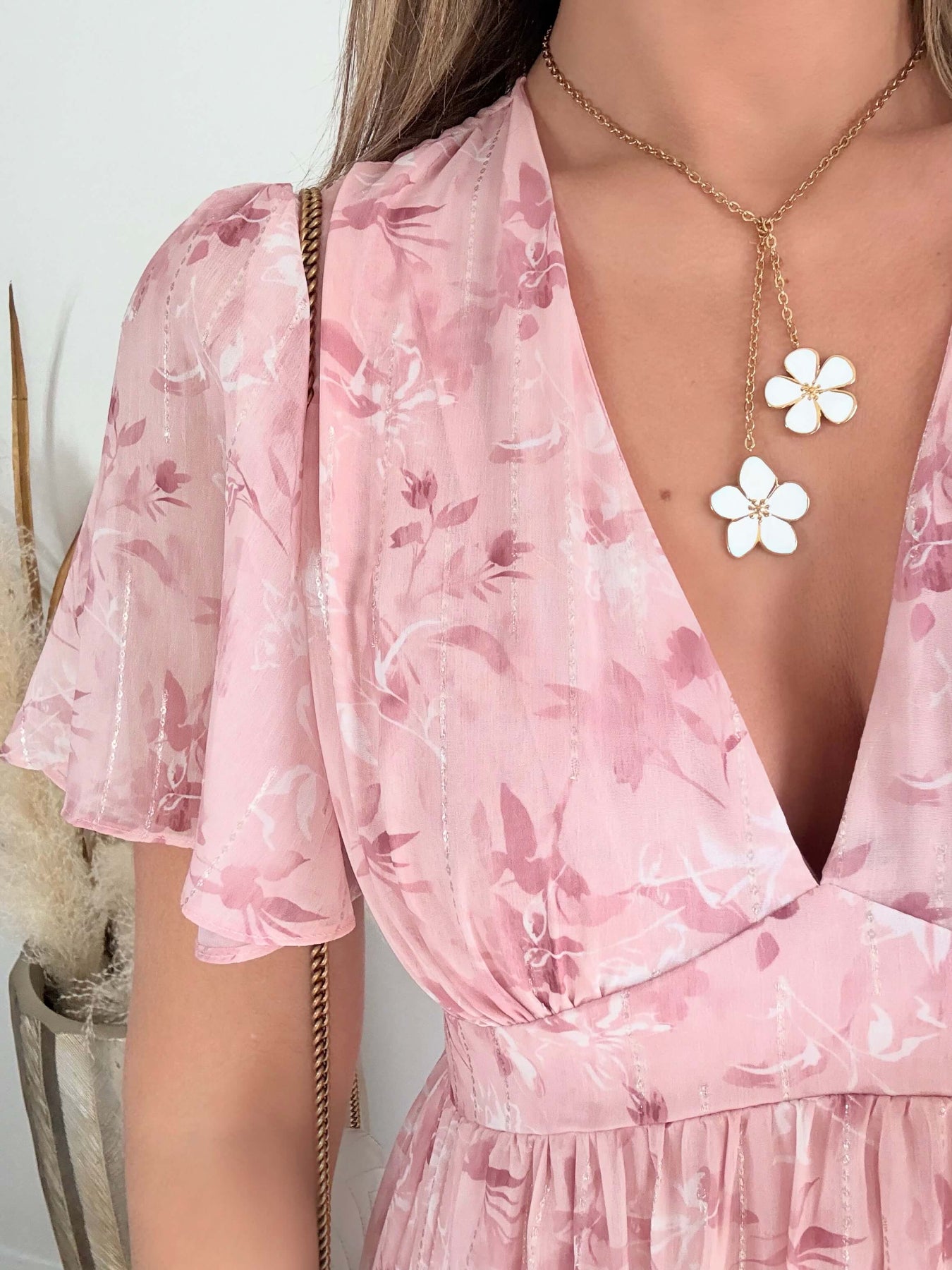 Robe longue rose poudré fleurie Naëlle avec manches fluides et décolleté cache-cœur portée par une femme.
