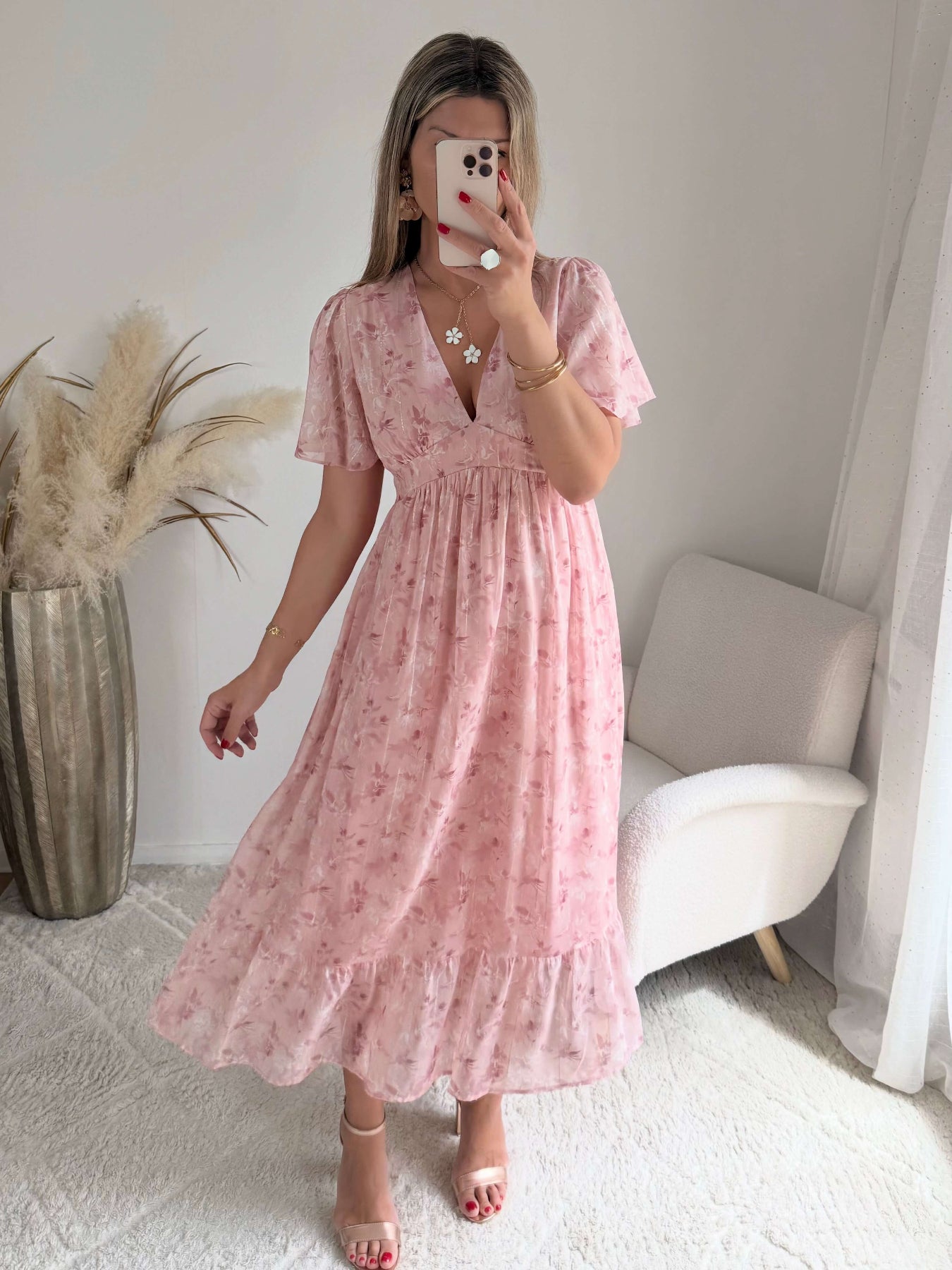 Robe longue rose poudré fleurie Naëlle avec manches fluides et décolleté cache-cœur portée par une femme.