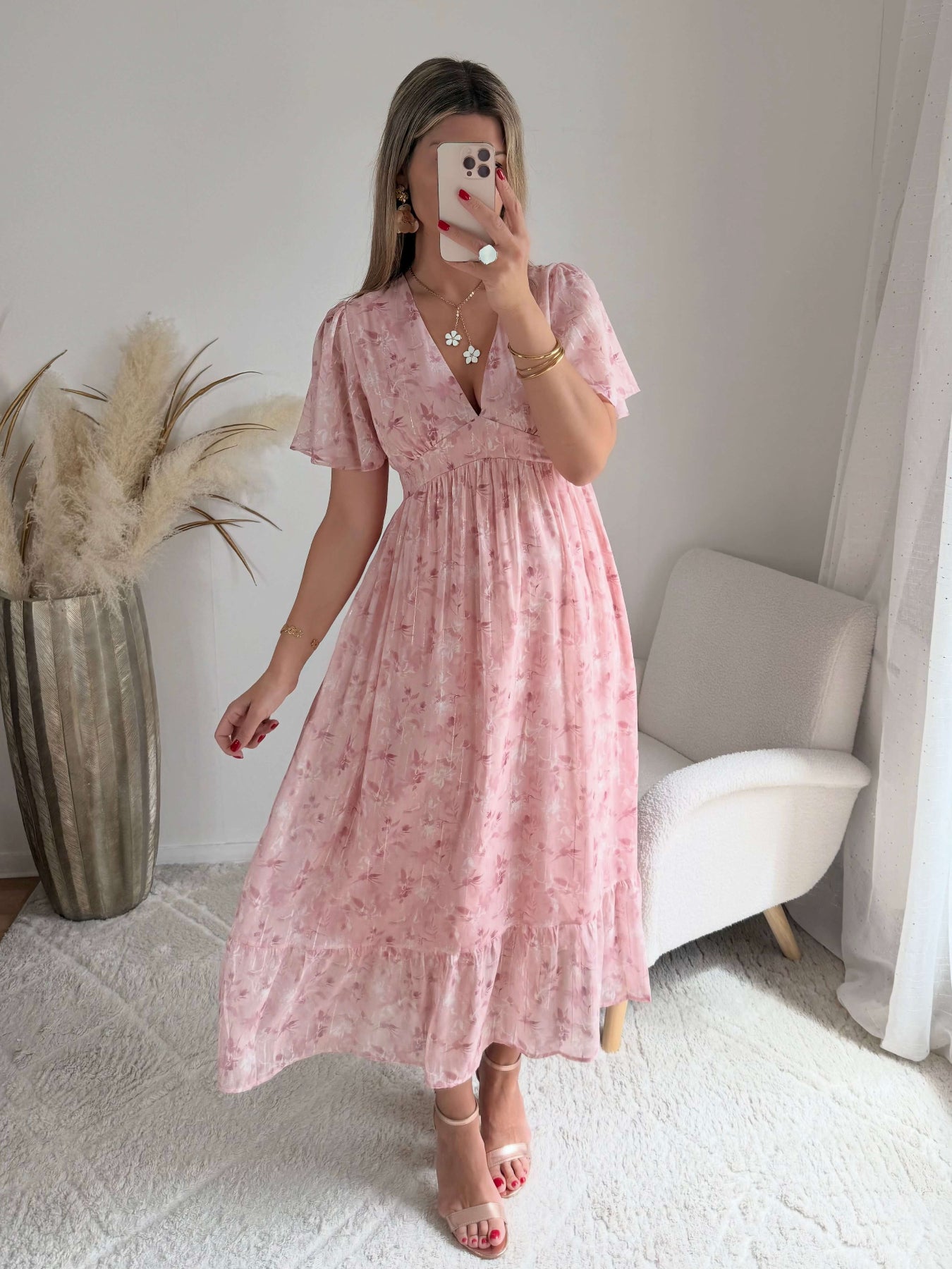 Robe longue rose poudré fleurie Naëlle avec manches fluides et décolleté cache-cœur portée par une femme.