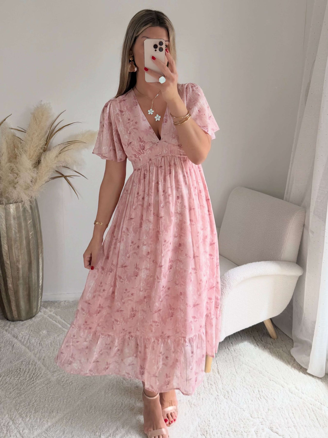 Robe longue rose poudré fleurie Naëlle avec manches fluides et décolleté cache-cœur portée par une femme.