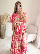 Robe longue tropicale rose Palma avec imprimé feuillage, manches fluides et coupe bohème chic.