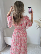Robe longue Laure imprimée rose coupe fluide avec décolleté en V et manches courtes.