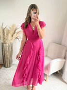Robe Madison longue fluide à volants avec décolleté cache-cœur et manches volantées, disponible en vert d’eau, rose poudré et fuchsia, taille unique du 36 au 42.