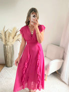 Robe Madison longue fluide à volants avec décolleté cache-cœur et manches volantées, disponible en vert d’eau, rose poudré et fuchsia, taille unique du 36 au 42.