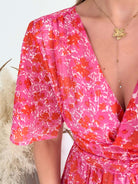 Robe longue Scarlett imprimée rose coupe fluide avec décolleté en V et manches courtes.