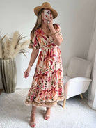 Robe longue Paloma imprimé tropical avec fleurs roses, palmiers terracotta et coupe bohème fluide.