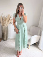 Robe Madison longue fluide à volants avec décolleté cache-cœur et manches volantées, disponible en vert d’eau, rose poudré et fuchsia, taille unique du 36 au 42.